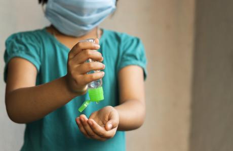 child with hand sanitizer